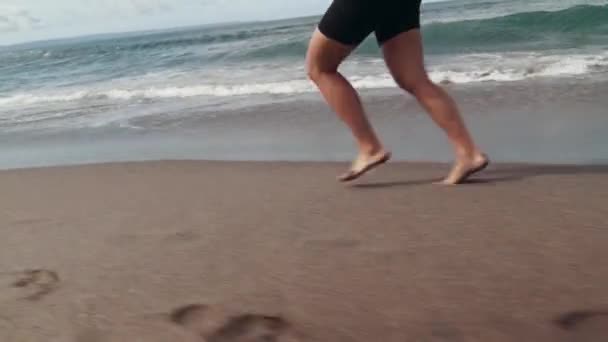 해변에서 달리 기를 하는 젊은 여자 운동 선수는 화창 한 날에 여성 단거리 달리 기 훈련을 실시 한다 — 비디오