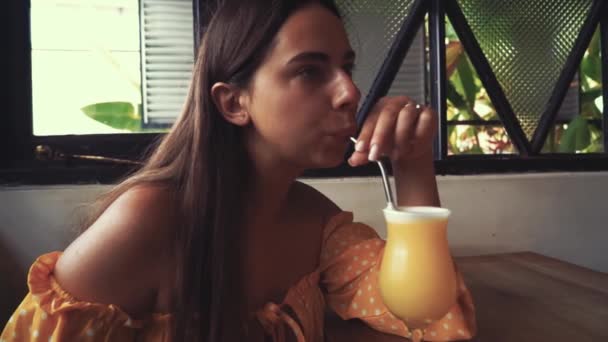 신선 한 열 대 망고 스무디 쥬스를 마시고 있는 매력적 인 젊은 여성은 버려 지지 않는 에코 친화적 인 금속으로 야채를 파는 식당을 사용 한다. — 비디오