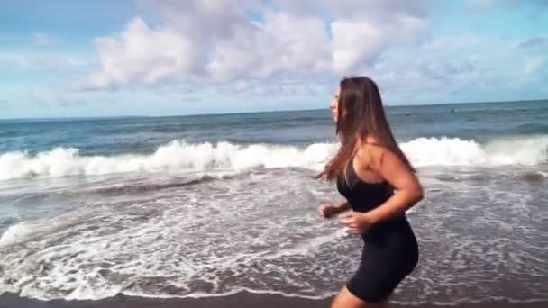 Young woman athlete running on beach exercising female runner sprinting training in the morning Sunny day — Stock Video