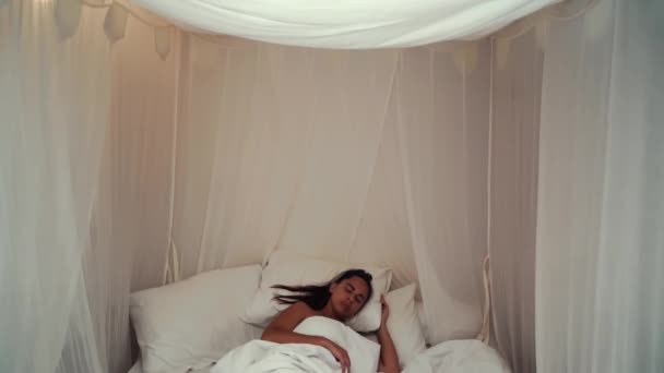 Calma giovane donna che dorme bene in confortevole accogliente letto fresco con baldacchino su morbido cuscino in lino bianco materasso ortopedico, tranquilla ragazza serena che riposa sdraiata addormentata godendo sano buon sonno pisolino in — Video Stock
