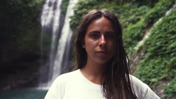 Ritratto di donna Enjoy Cascade Waterfall View. Giovane ragazza caucasica leggermente sorridente. Pam Bok Water Creek che scorre nella giungla. Indonesia Bali — Video Stock