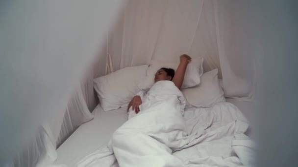 Young irritated woman trying to sleep annoyed by bad noisy room neighbors covering ears with pillow, angry girl student disturbed with loud noise problem wake up lying in bed suffer from insomnia — Stock Video