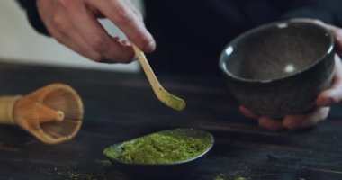 Adam kaseye kibrit yeşil çay tozu ekliyor. Kibrit Organik Yeşil Çay. Matcha Çay Töreni. Yakın çekim.