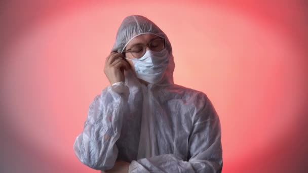 Een persoon in een beschermend pak, verwijdert het medische masker en ademt frisse lucht zonder virussen. Het begrip gezondheid en vrijheid zonder coronavirus — Stockvideo