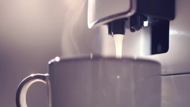 Proceso de elaboración de café capuchino o latte en máquina de café. Café listo con leche cayendo en taza blanca. Café de la mañana en el desayuno — Vídeo de stock