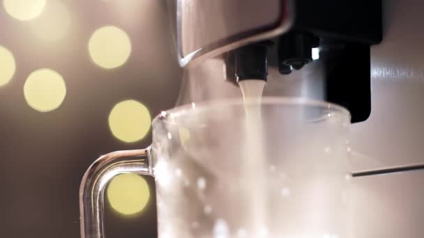 Proceso de elaboración de café capuchino o latte en máquina de café. Café listo con leche cayendo en taza de vidrio. Café de la mañana en el desayuno — Vídeo de stock