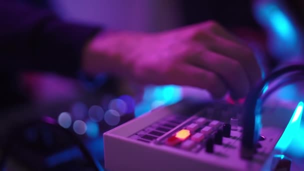 Primer plano de manos hombre DJ reproducción de música en casa taller de estudio de grabación. Estudiante aprende a escribir música ambiente creativo. Formación en educación en línea. Productor de sonido. Luz de neón colorida — Vídeo de stock
