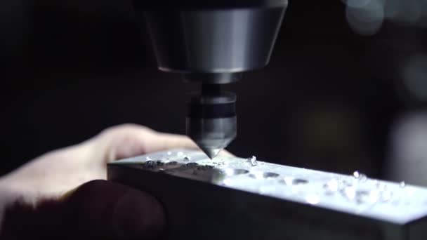 Vridna bitar av överskottsmetall flyger av en bit aluminium under svarvning med en CNC-borr. Finskuren kvarn som rakar sidan av ett matt metallblock. — Stockvideo