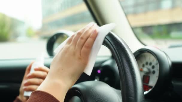 Закрыть руки водителя с помощью антибактериального геля для дезинфекции руля автомобиля против коронавируса или Covid-19 — стоковое видео