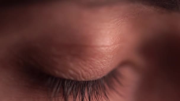 Een vrouw met blauwe ogen die mascara draagt, opent haar ogen in een profiel van dichtbij. — Stockvideo