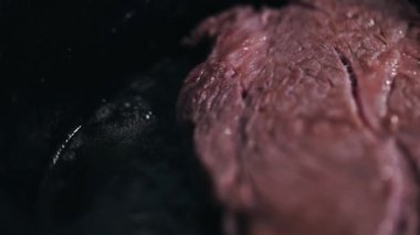 Şef tavada biftek fileto pişirdi. Kızarmış biftek, çiğ et. Et kızartılıyor ve tavada ısıtılıyor. makro yakın çekim.