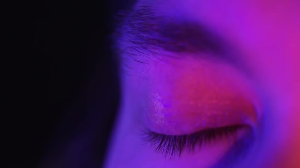 Nahaufnahme Makroblaue Augen öffnen schöne Iris natürlichen Menschen in Neonlicht. Schönheit und gesundes Sehvermögen — Stockvideo