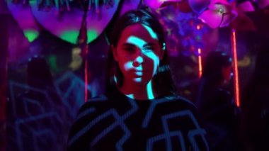 Renkli Filtrede Kameraya Bakan Kızın Portresi. Neon Işıklı Karanlık Oda 'da Çok Renkli. Genç Bir Kadınla Moda 'nın Geleceğin Reklamı. Gecenin Ultra-Violet Işığında İzleyen Kadın