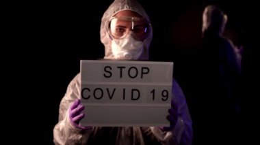 Doktor, virolog, bilim adamı, kimyasal koruma giysisi giyen adam, solunum cihazıyla işaret koronavirüsü tutan adam..