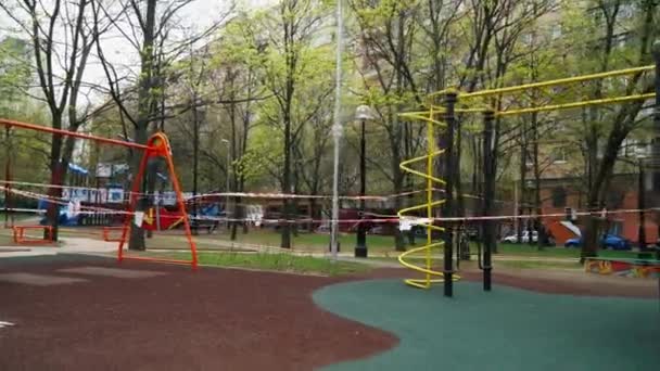 Çocuk parkı karantina döneminde çocuklara ve oyunlara kapalıdır. Çocukların oyun alanı koruyucu bantlarla kaplı. Moskova 'daki olaylar covid-19 Coronavirus' la savaşmak için — Stok video