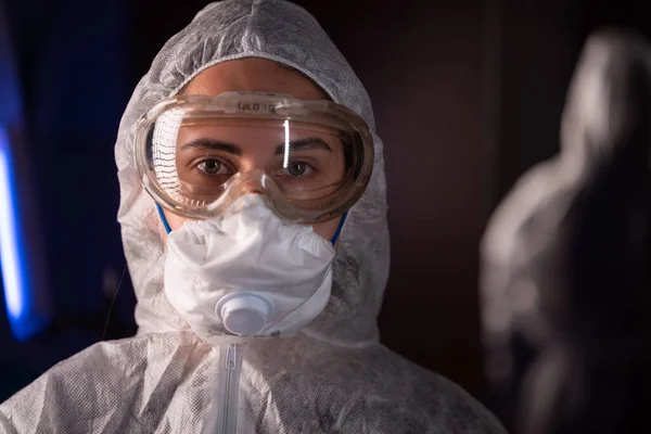 Portré epidemiológus védi a betegeket a coronavirus COVID-19 maszkban. Orvos virológus, öltönyben és szemüvegben dolgozik a laborban. A homálytól való megjelenés Stock Kép
