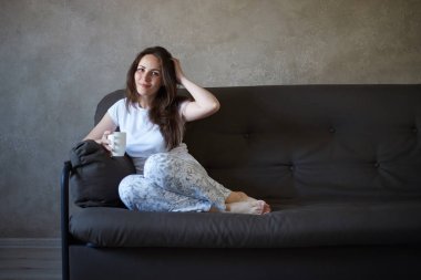 Kanepe ve çay içme kadın oturur