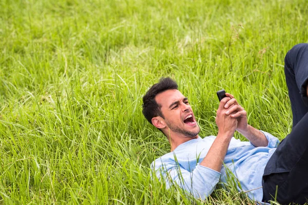 Smutný obchodní muž s telefonem na zelené trávě. — Stock fotografie