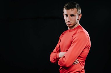 Koyu arka plan üzerinde duran, onun hayatında sorunları üzerinde düşünme, el ele tutuşarak ve uzağa arıyorsunuz kırmızı spor giyim çekici sporcu adam. Yaşam tarzı, spor, motivasyon.