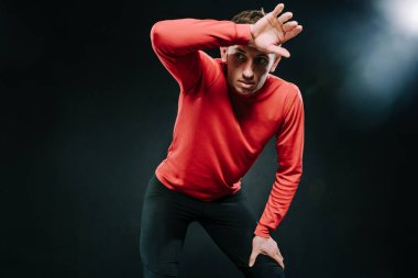 Yakışıklı ciddi adam atlet spor salonunda, sert çalışmadan sonra rahatlatıcı portresi elini kafasına koydu. Kırmızı spor giyim giyen sportif adam ağrı var. Spor için yaşam tarzı ilham. Motivasyon.