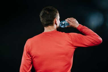 Arka kırmızı spor giyim içme suyu giyiyor, yoğun beden eğitimi spor salonunda sonra rahatlatıcı yakışıklı kaslı Kafkas jogger portresi vurdu. Spor motivasyon. Yaşam tarzı.