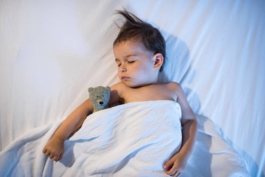 Bebek beyaz yatakta uyuyan güzel manzarasını yukarıdan