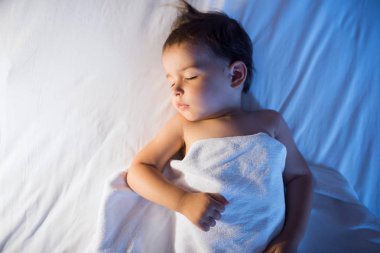 N beyaz yatakta uyuyan sevimli bebek kız yukarıdan görüntülemek