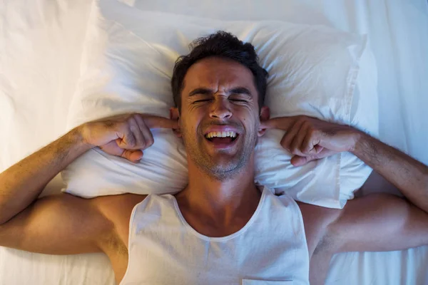 Guapo joven sonriente usando un teléfono móvil y mensajería en — Foto de Stock