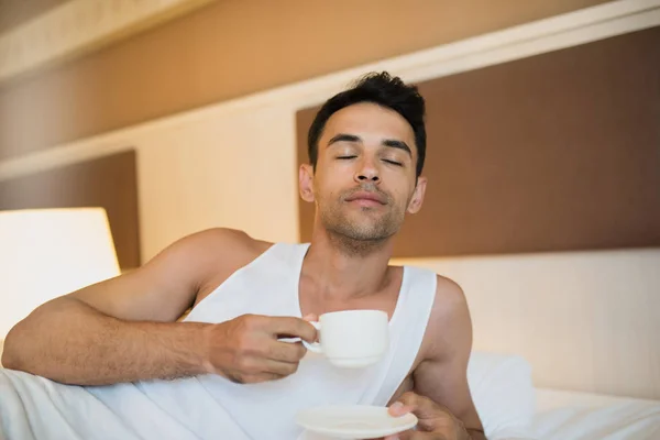 Portrait of handsome young awake man drinking cup of coffee with — Stock Photo, Image