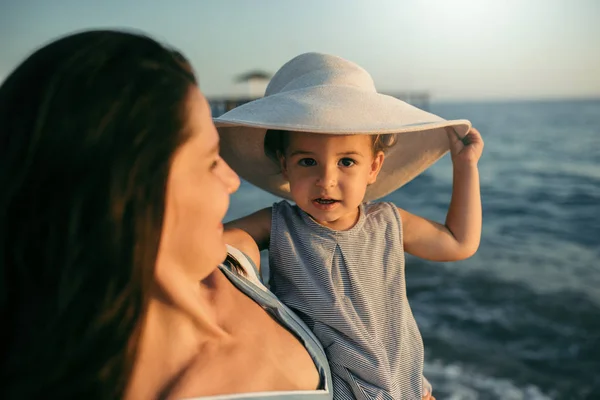 Vackra porträtt av mor och dotter spela med hatt på s — Stockfoto