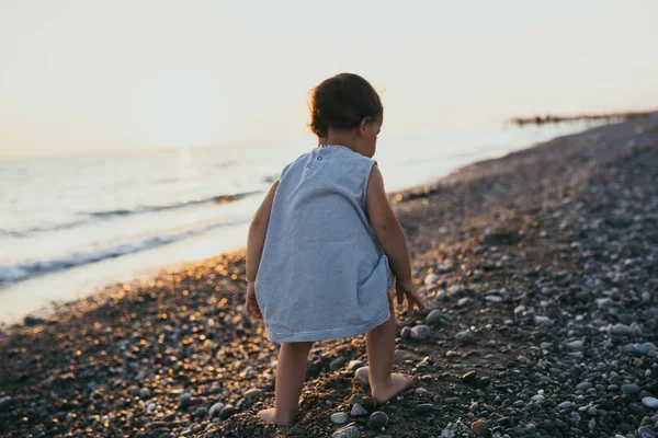 바다 해변 일몰 backgro에서 다시 보기 귀여운 여자 아이 플레이 — 스톡 사진