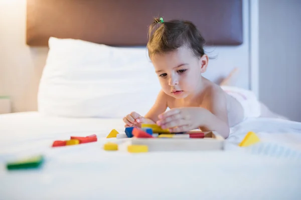 유아 장난감 엉망와 재생에 침대에 누워 아름 다운 소녀 — 스톡 사진