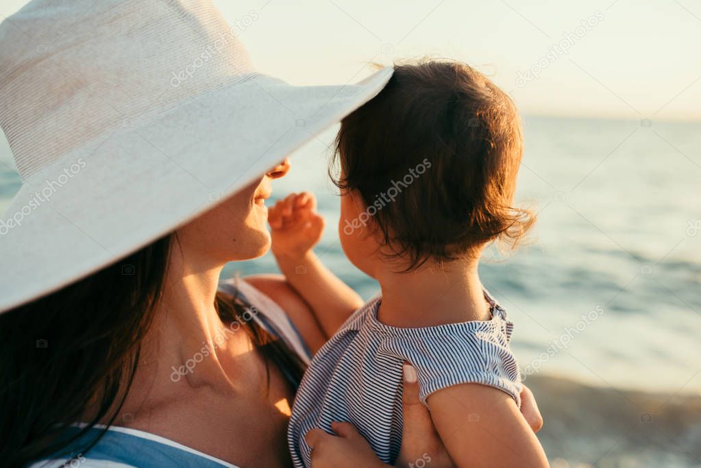 Close up portrait back view of young mother kiss daughter at the