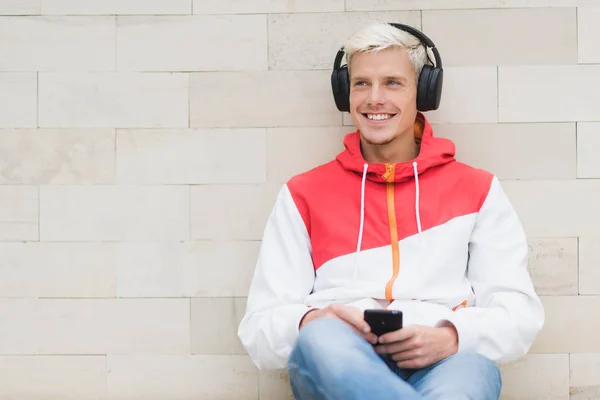 Candid shot of happy smiling male dressed in red sportswear rela