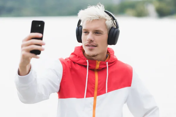 Mladá blonďatá bokovky muž v módní červené zip hoodie a lis — Stock fotografie