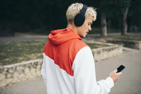 Красивий блондин хіпстер слухає аудіокнигу, використовуючи голову — стокове фото