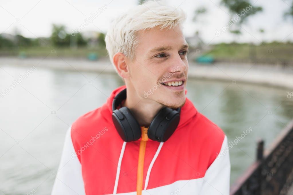 Good-looking smiling attractive blond handsome man with headphon