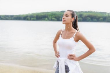 Esmer genç fitness spor eğitim açık havada güzel güneşli gün sonra kulaklık ile müzik dinleme kadında. Kulaklık smartphone üzerinden doğa ve dinle müzik keyfi kız runner.