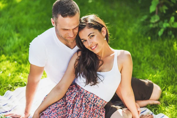 Portrait of cute couple in love sitting on a picnic blanket outd — Stock Photo, Image