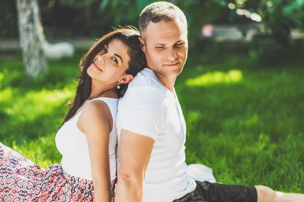 Cute couple in love sitting on a picnic blanket outdoor. Caucasi — Stock Photo, Image