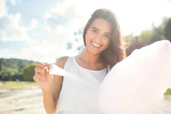 Beau portrait de jeune femme heureuse avec des barbe à papa avec des cheveux venteux, sourire et marcher dans le parc . — Photo