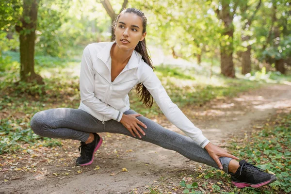 Schöne sportliche kaukasische brünette Frau dehnen nach r — Stockfoto