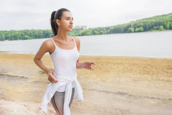 Portrait of beautiful athletic brunette female runner jogging in — Stock Photo, Image