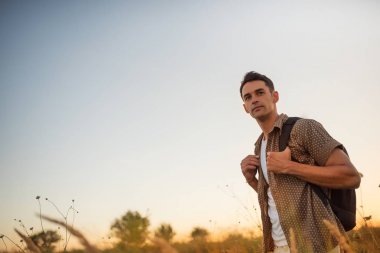 Yakışıklı beyaz adam onun omuzlarında bir sırt çantası ile seyahat gitmek zamanı. Turizm kavramı. Aktif spor adam macera seyahat.