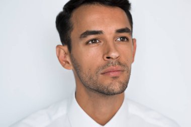 Yakın çekim portre stresli yakışıklı genç adamın beyaz veya açık gri arka plan üzerinde kötü baş ağrısı ile kafasına el. Negatif insan duygu yüz ifadesi duygu. Sağlık ve tıp Tema.