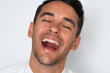 Yakın çekim portre çekici mutlu man gülüyor. Gri arka plan üzerinde izole. Adam sağlıklı dişlere sahip. Diş Bakımı.