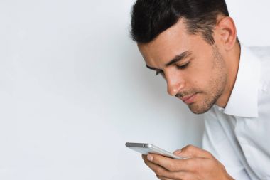 Yakışıklı bir adam portresi cep telefonu gri arka planı izole metin gönderin. Teknoloji ve bağlantı fikir. Genç Beyaz işadamı Studio akıllı telefon ile poz.