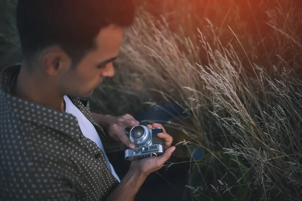 Vue d'en haut d'un adorable portrait en gros plan d'un jeune homme avec caméra vintage sur champ, herbe, nature, fond. Voyage. Image de fond. Automne. Été — Photo