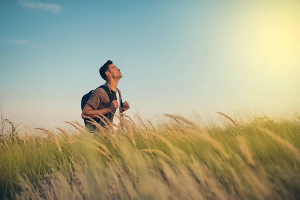 Handsome caucasian man look at the sun with a backpack on his shoulders, time to go traveling. Tourism concept. Travel adventure of active sport man. Exploration of nature. — Stock Photo, Image