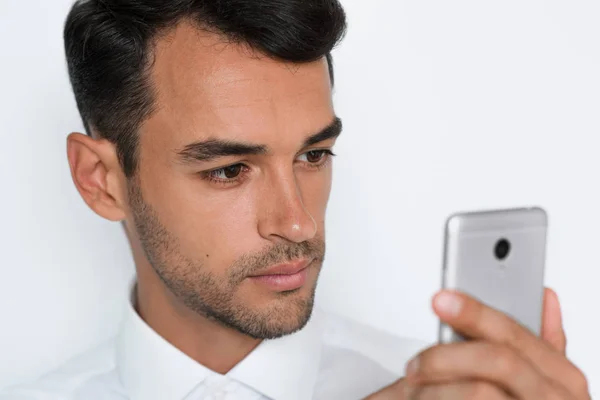 Belo retrato de close-up do jovem usando telefone celular em fundo cinza. Empresário falando em seu telefone inteligente. Rosto cortado . — Fotografia de Stock